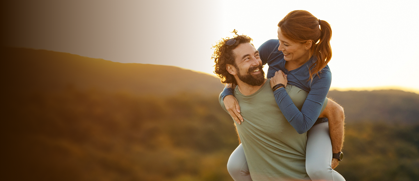 Bearded man carrying a woman on his back